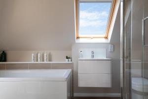 a white bathroom with a sink and a window at Lewes Heights is a spacious modern luxury home with stunning views in Lewes