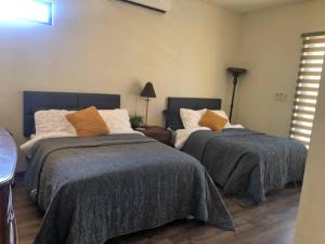 1 dormitorio con 2 camas y lámpara en Hermosa residencia de lujo, en Hermosillo