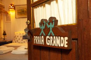 a sign on a door that reads prairie grande at Pousada das Meninas in Ilha do Mel