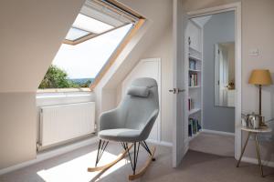una silla en una habitación con ventana en Lewes Heights is a spacious modern luxury home with stunning views, en Lewes