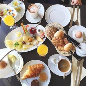 una mesa con platos de comida y bebida para el desayuno en Passion by Nights & Smiles en Tuzla