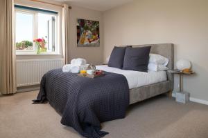 Un dormitorio con una cama con una bandeja de comida. en Lewes Heights is a spacious modern luxury home with stunning views, en Lewes