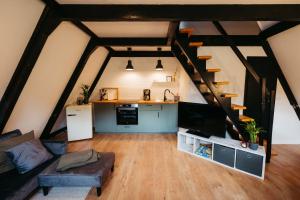 a living room with a loft with a kitchen and stairs at Gemütliches Nurdachhaus im Naturparadies mit Sauna - Erholung pur in Bad Wünnenberg