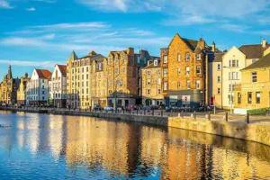 a city with buildings next to a river at Spacious 2 Bed, 2 Bath apartment -The Shore, Leith in Edinburgh