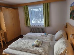 two beds in a room with green curtains and a window at Haus Ortsblick in Wagrain