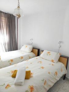 2 aparte bedden in een kamer met witte muren bij Habitaciones Valén in Zaragoza