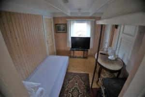 Habitación pequeña con cama y TV. en Gammelstua, en Hitra