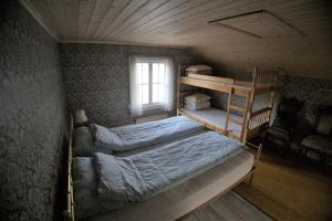 a bedroom with two bunk beds and a window at Gammelstua in Hitra