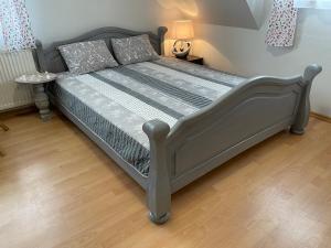 ein großes Bett in einem Schlafzimmer mit Holzboden in der Unterkunft Willa Bursztyn in Dębki