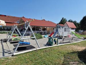 einen Spielplatz mit mehreren Schaukeln und Rutschen in einem Hof in der Unterkunft Sangos Ośrodek Sportowo-Szkoleniowy in Górki Wielkie