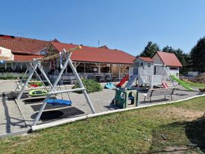 a playground with several swings and slides in a yard at Sangos Ośrodek Sportowo-Szkoleniowy in Górki Wielkie