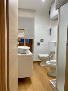 a bathroom with two toilets and a sink at Desiree Apartment in Folgarida