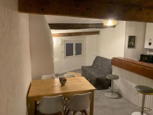 salon ze stołem, krzesłami i kanapą w obiekcie Superbe duplex vue montagne. w mieście Gréolières
