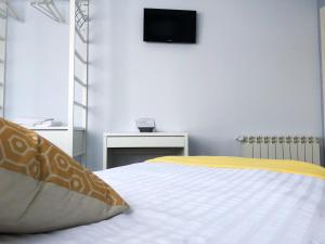 sypialnia z łóżkiem z telewizorem na ścianie w obiekcie Alojamiento HC w mieście Colmenar Viejo