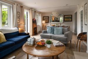 uma sala de estar com um sofá azul e uma mesa em Lewes Heights is a spacious modern luxury home with stunning views em Lewes