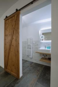 a bathroom with a wooden door and a sink at Maneki Serra 1/2D in Bologna