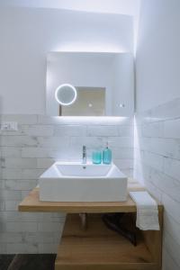 a bathroom with a white sink and a mirror at Maneki Serra 1/2D in Bologna
