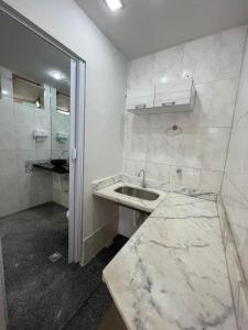 a white bathroom with a sink and a toilet at Da Orla Pampulha Hostel in Belo Horizonte