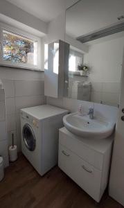 y baño con lavadora y lavamanos. en Stilvolle Wohnung in Elbnähe mit Balkon, Parkplatz, en Dresden