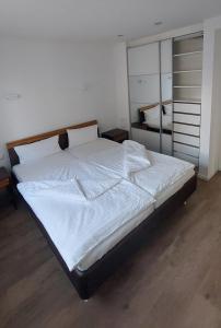 1 dormitorio con 1 cama grande con sábanas blancas en Stilvolle Wohnung in Elbnähe mit Balkon, Parkplatz, en Dresden