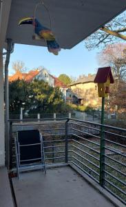 un alimentador de aves y una silla en un porche en Stilvolle Wohnung in Elbnähe mit Balkon, Parkplatz, en Dresden