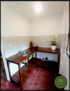 baño con lavabo y mesa de madera en Vieja Cepa Departamento en San Rafael