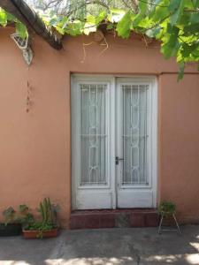 un par de puertas blancas en una casa rosa en Vieja Cepa Departamento en San Rafael