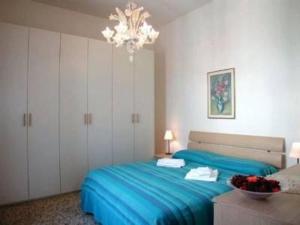 een slaapkamer met een blauw bed en een kroonluchter bij Ca' Gioiosa Venice in Venetië