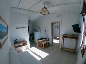 a living room with a table and a television at Condomínio Aldeia dos Anjosdo Rosa in Praia do Rosa +42 photos