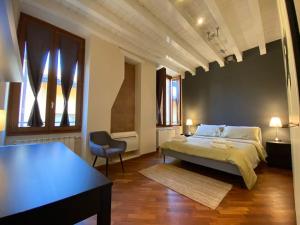 een slaapkamer met een bed, een tafel en een stoel bij A view on Brescia's rooftops in Brescia