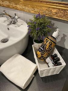 a bathroom with a sink and a basket with a bottle of alcohol at A view on Brescia's rooftops in Brescia