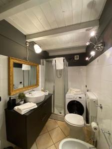 een badkamer met een toilet, een wastafel en een douche bij A view on Brescia's rooftops in Brescia
