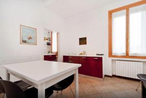 威尼斯的住宿－威尼斯吉奧伊奧薩公寓，厨房配有白色桌子和红色橱柜