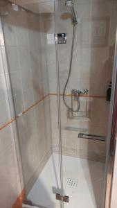 y baño con ducha y puerta de cristal. en Islantilla-Apartamento con piscina y garaje en primera línea de playa, en Isla Cristina