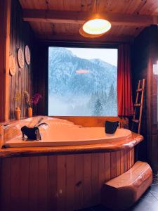 a bath tub in a room with a large window at Kukudi House in Ayder Yaylasi