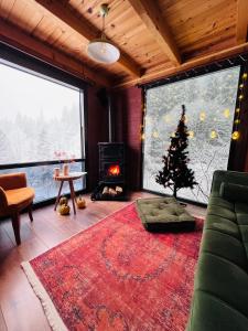 a living room with a christmas tree and a fireplace at Kukudi House in Ayder Yaylasi