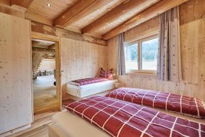 Duas camas num quarto com paredes de madeira em Haus im Giessen em Oetz