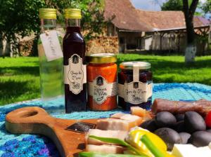 a table with two bottles of sauce and vegetables at La Bunu Nic in Porumbacu de Sus