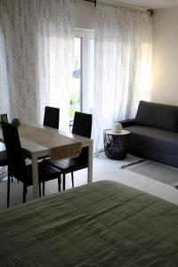 uma sala de estar com uma mesa e cadeiras e um sofá em Apartament Niechorze em Niechorze