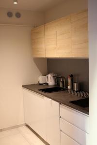 a kitchen with white cabinets and a counter top at Apartament Niechorze in Niechorze