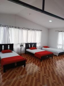 Duas camas num quarto com pisos em madeira em Finca Hotel el Guadual em Quimbaya