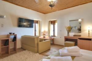 a living room with a bed and a chair and a desk at Casa Margarita cozy & peaceful stay in Tzoumerka in Ioannina