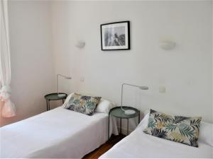 a bedroom with two beds and two tables at Charmant T2 bord de mer in Anglet