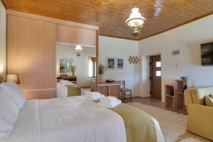 Casa Margarita cozy & peaceful stay in Tzoumerka في يوانينا: غرفة نوم بسرير ابيض كبير ومرآة