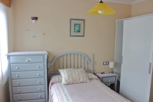 a small bedroom with a bed and a dresser at Caracas in Lalín