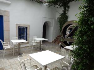 a patio with white tables and chairs and a staircase at Dar Fatma in Sidi Bou Saïd