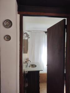 a bathroom with a sink and a mirror at El Espinillo, Casa de Campo in Santa Rosa de Calamuchita