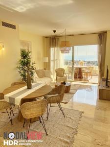 ein Wohnzimmer mit einem Tisch, Stühlen und einem Sofa in der Unterkunft Beautiful appartment Mijas Costa in Mijas