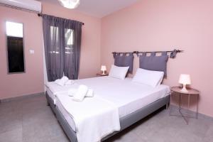 1 dormitorio con 2 camas con sábanas blancas en Casa Di Nina, en Ýpsos