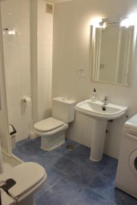 ラリンにあるCaracasの白いバスルーム(トイレ、シンク付)